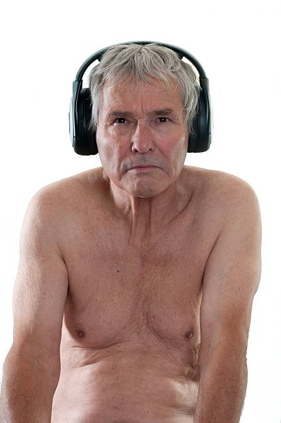 Senior man with headphones, naked shoulders, belly and chest stock photo
