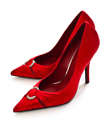 bright red high-heeled shoes stand on a dark background