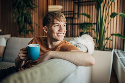 Man sitting on sofa at home.