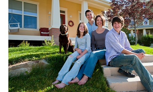 Modern family in front of new home with copy-space
