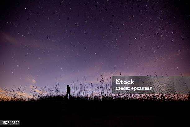 Foto de Solitary Figura Admira O Céu Em Uma Clara Estrelado e mais fotos de stock de Noite