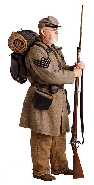 Re-enactor portraying a confederate 1st Sergeant, with full pack and bedroll, rifle and bayonet. There is a lot of intricate detail in this image.