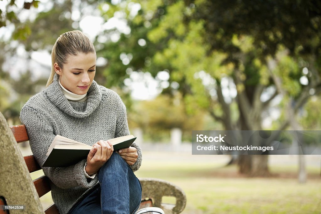 Lectura de mujer en el parque - Foto de stock de 20 a 29 años libre de derechos