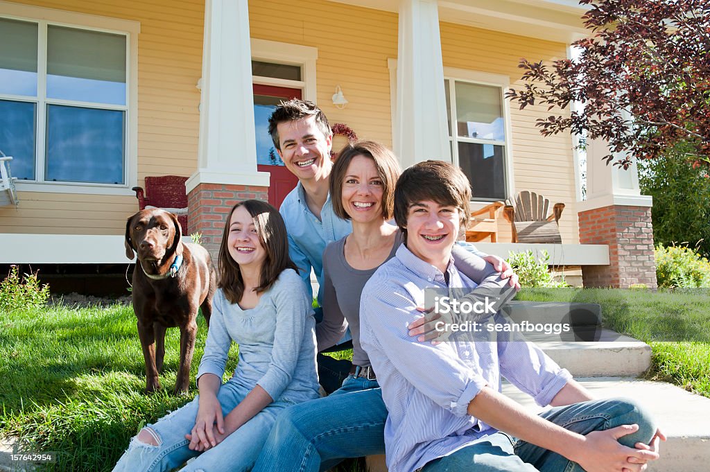 Family sitting together with dog outside of new home Family sitting together with dog outside of new home with copy-space Chocolate Labrador Stock Photo