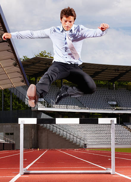 istock Young energetic businessman jumping over the hurdle 157643132