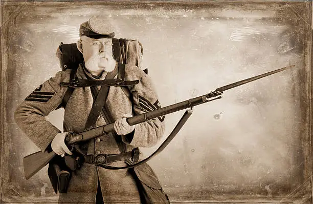 Re-enactor portraying an American Civil War Confederate Soldier. Image manipulated - Sepia tone and distressing effects created in Photoshop to make this look like an old print.