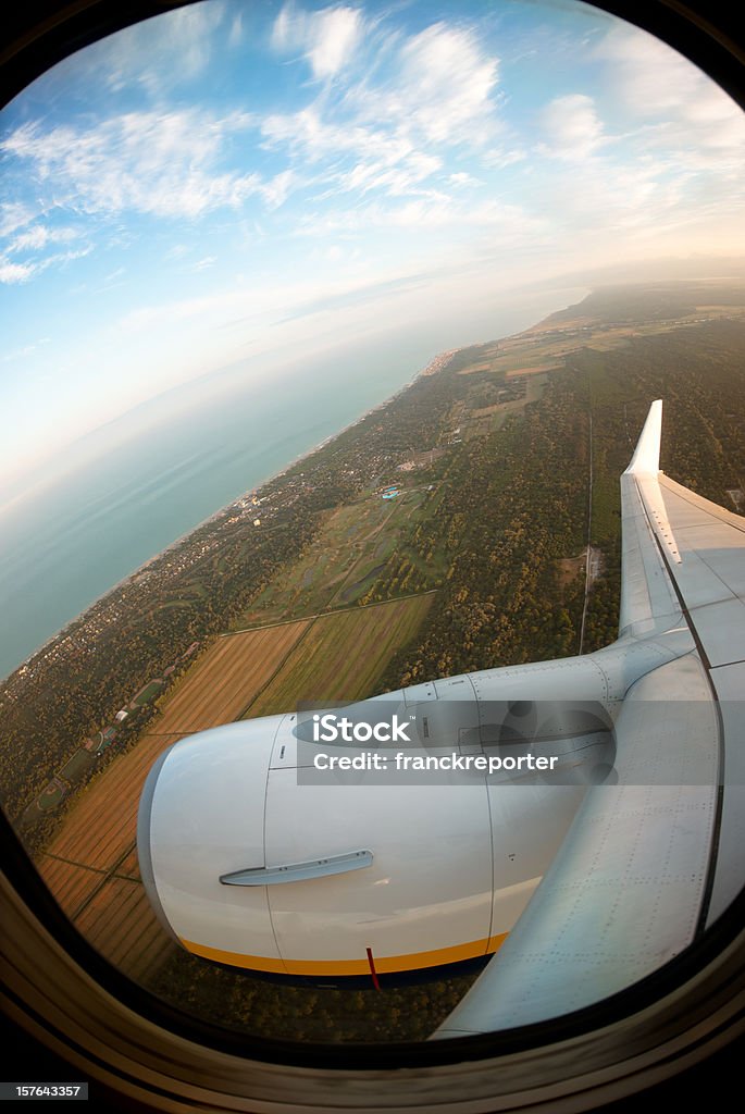 Vista da janela do avião ao pôr-do-sol da costa - Foto de stock de Janela royalty-free