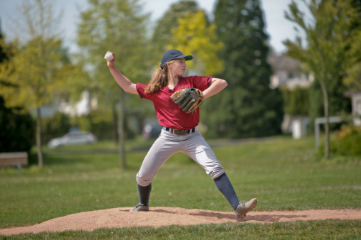 Baseball, sport and ball with a sports woman, athlete or pitcher throwing and pitching a ball during a game or match on a court. Fitness, workout and exercise with a female athete training outside