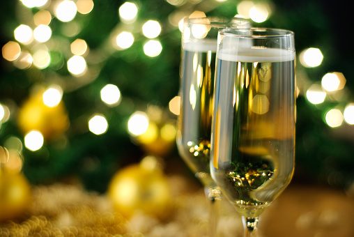 Two glasses of champagne in front of the defocused blinking christmas tree.