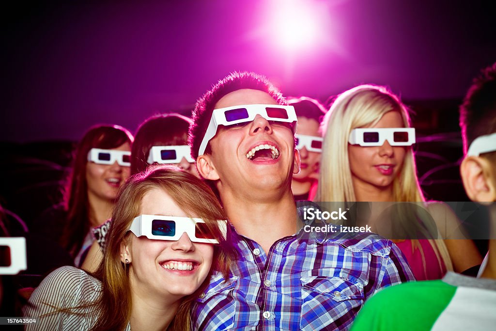 Date in 3D movie theater Young adult couples wearing 3D glasses, sitting in the cinema and watching 3D movie. They laughing and having fun. Movie Stock Photo