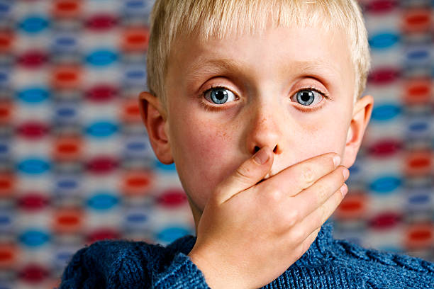 Blond boy makes the 'Speak no Evil' gesture  little boys blue eyes blond hair one person stock pictures, royalty-free photos & images