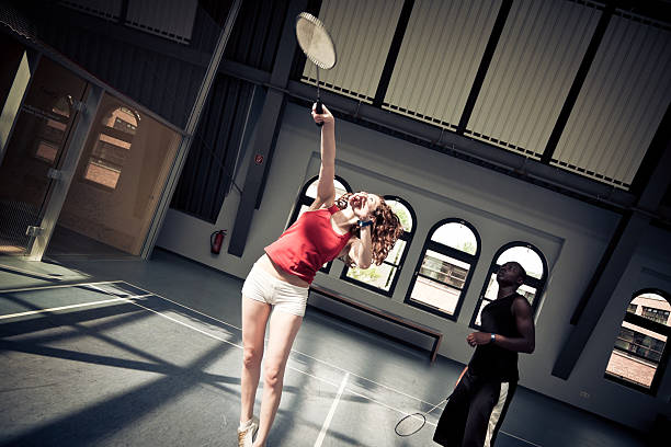 young people playing badminton at the gym