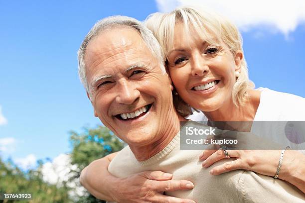 Feliz Homem Idoso Piggybacking Mulher Contra Céu - Fotografias de stock e mais imagens de Casal Idoso - Casal Idoso, Face Humana, Sorrir