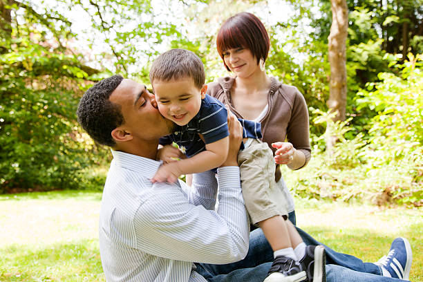 familia joven jugando en el parque - family grass toddler african descent fotografías e imágenes de stock