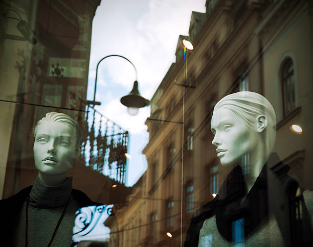 Fashion store window, with mannequins on display and the reflection of city (cross processing).
