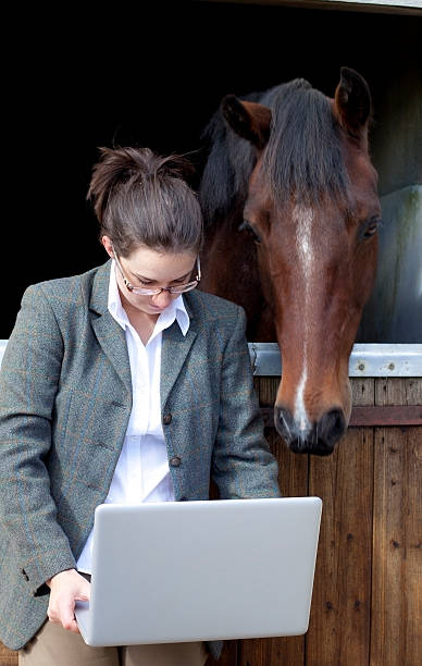 istock young woman with computer and horse 157644292