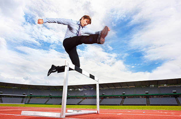 istock Young energetic business executive jumping over the hurdle 157644309