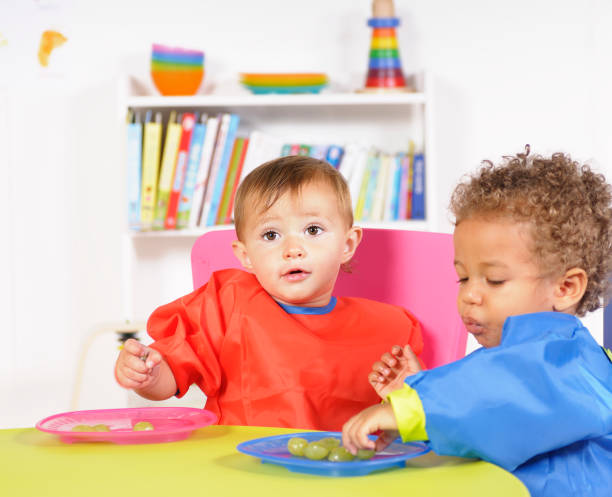 istock Pair Of Babies Eating Grapes In A Nursery Setting 157644425