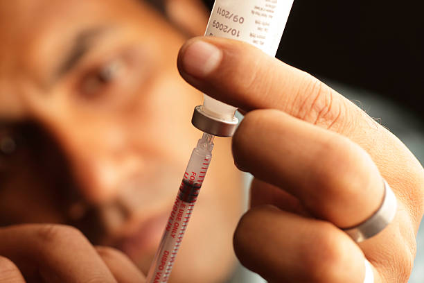 A male loading insulin into a needle stock photo