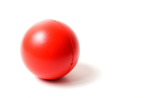 Red stress ball isolated on white background. High key image with copy space