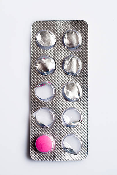блистерная упаковка с одной розовая таблетка оставшиеся, крупный план - pill container стоковые фото и изображения