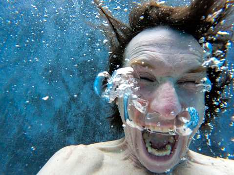 Man underwater with bubbles in pool in Toronto Canada