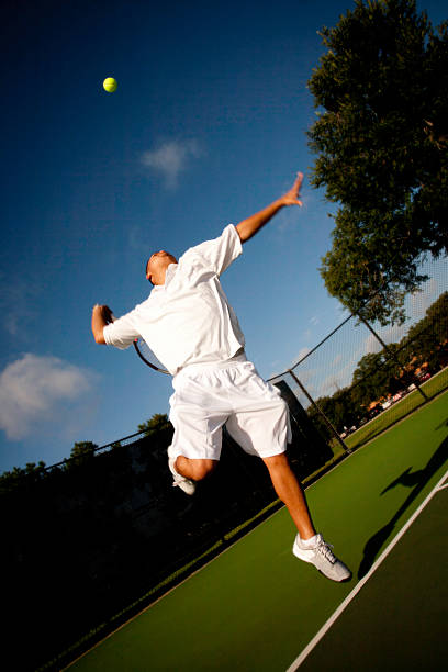 istock Tennis Player in Mid Serve on a Deep Blue Sky 157644784