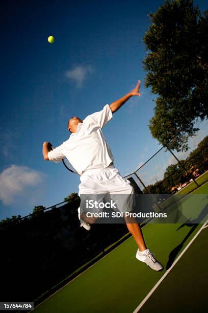 Tenisistka W Połowie Służyć Na Głęboki Niebieski Niebo - zdjęcia stockowe i więcej obrazów Tenis