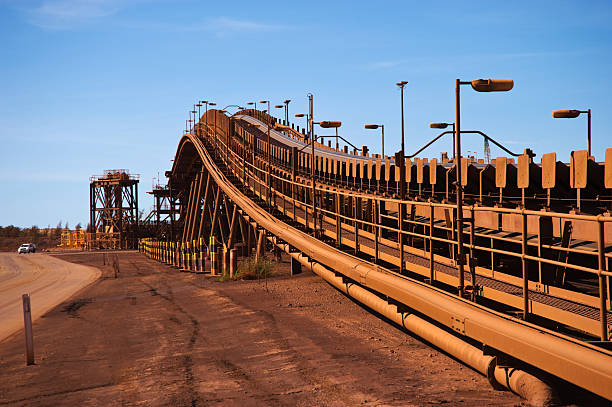 Red brown conveyor belts on the iron ore mine site Iron Ore Mine Site Port Hedland Western Australia Pilbara Reclaimer stock pictures, royalty-free photos & images