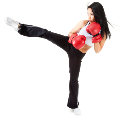 Photo of an attractive youn Asian kick boxer wearing red boxing gloves; isolated on white.