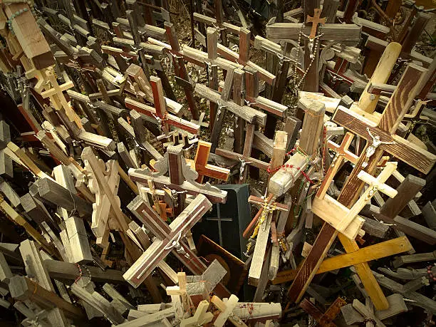 Many Catholic Crosses with the likeness of Jesus Christ. Hill of Crosses, Holy Mountain, Kryžių kalnas, Lithuania, Europe. The place of pilgrimage for Catholics from around the world. Natural dust and scratches visible.