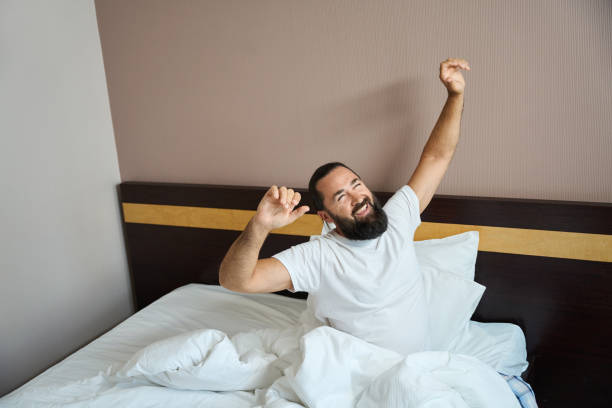 istock Joyful man wakes up in a bright hotel room 1576459492
