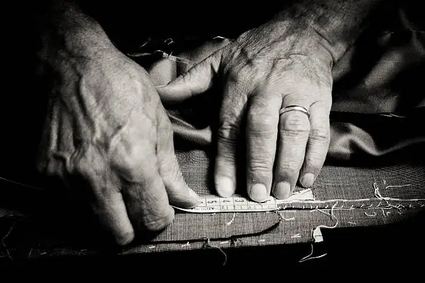Close up of a older man at work as a tailor.