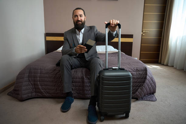 istock Male with passport in his hands sat down on bed 1576460273
