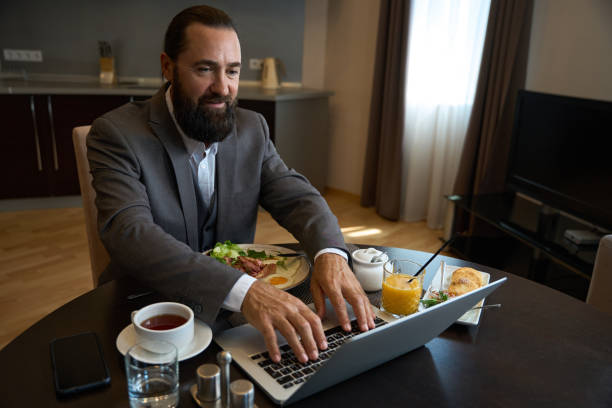 istock Hotel guest chatting online during breakfast 1576460816
