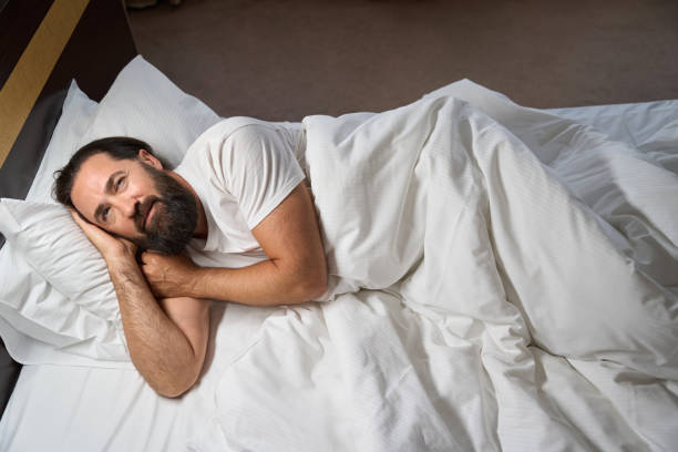 istock Awakened male basks in a big bed 1576460919