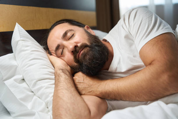 istock Bearded man sleeps in a bright hotel room 1576460938
