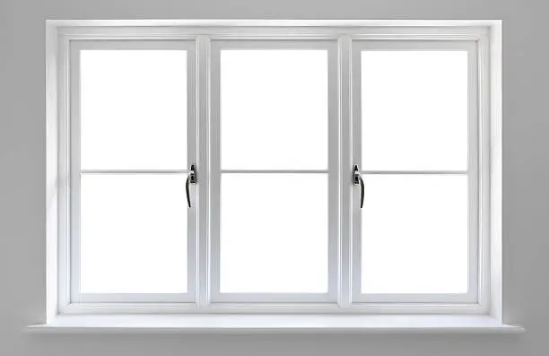 very high quality manufactured wooden window frames with double glazed units set in a recess surrounded by a light grey wall. 