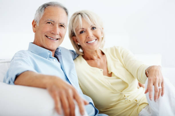 istock Smiling mature man with his wife sitting together on sofa 157646700
