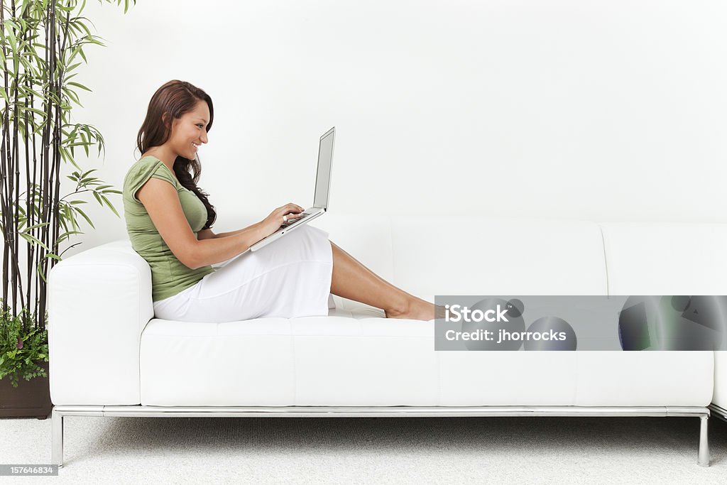 Jovem mulher em um sofá com Laptop - Foto de stock de Laptop royalty-free