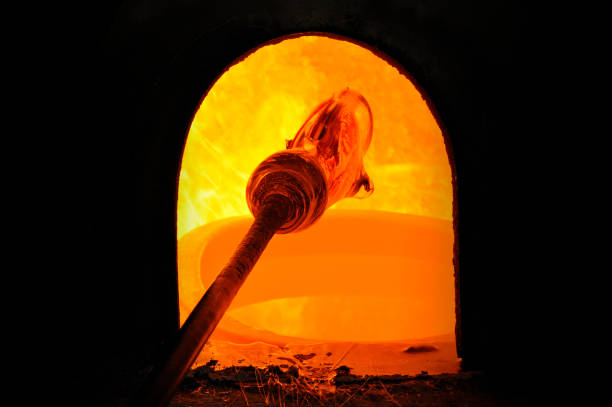 view into the open door of a red hot furnace, glowing refractory lining and with a freshly removed hot crucible in front. In South Africa refining gold, though it could be any metal or glass melting process