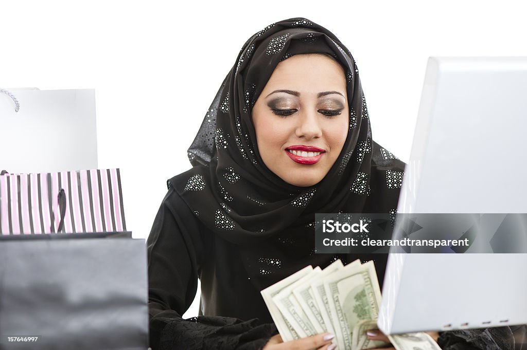 Happy Arabic girl shopping on the internet  Currency Stock Photo