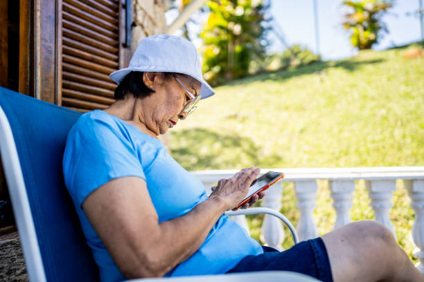 istock Senior woman using mobile phone in a balcony 1576471458