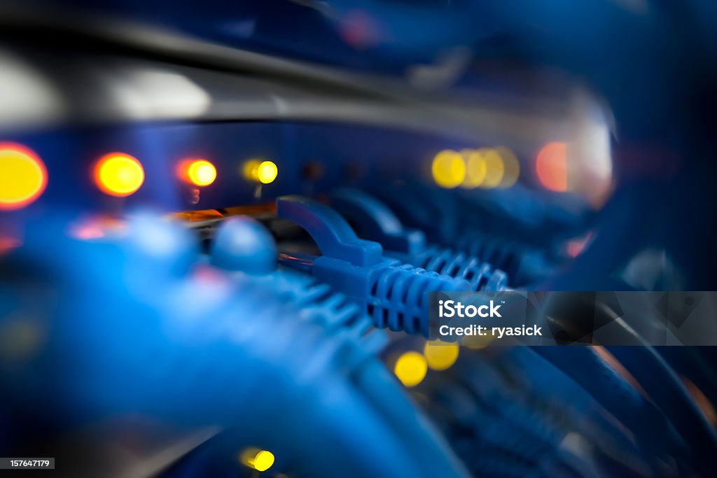 Closeup Of A Server Network Panel with Lights and Cables Selective focus closeup view of cables plugged into a server network panel with lights indicating activity. Photographed inside an equipment room.  Canon 5D MarkII. The file has been meticulously retouched in Photoshop eliminating dust and unwanted flaws. I have over 22 years experience as a photo retoucher. Cable Stock Photo