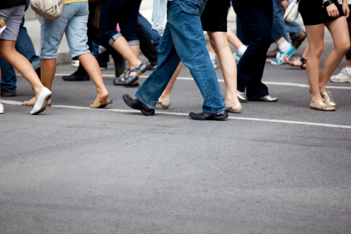 Focal point on asphalt midpoint; busy crosswalk scene.  Summer in New York City.