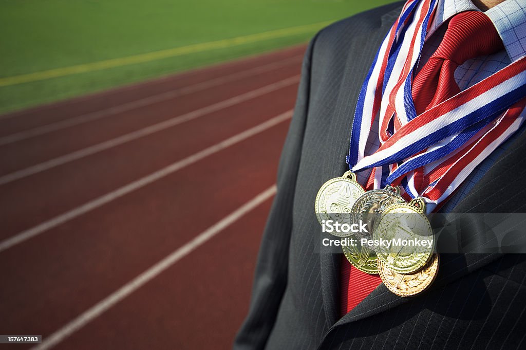 Empresário coberto com medalhas pista de corrida de fundo - Foto de stock de Medalha de ouro royalty-free