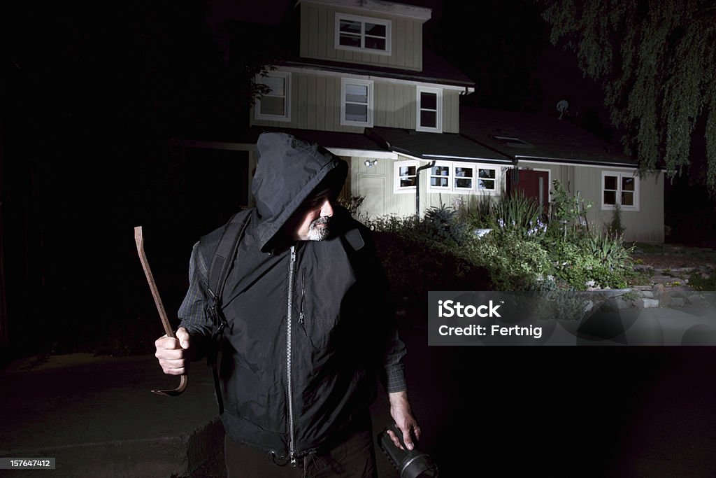 Burglar contemplating breaking-in to a home.  Burglary Stock Photo