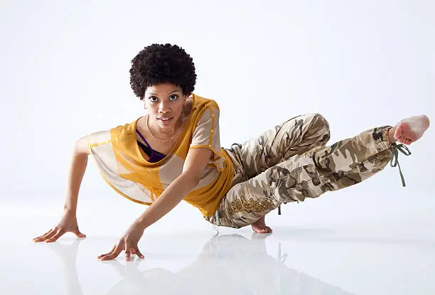 African-American female hip hop dancer posing, looking at camera, on white background
