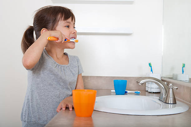 jeune fille se brosser les dents - healthcare and medicine home interior side view vertical photos et images de collection