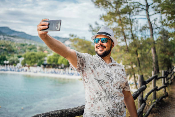 istock Smiling man taking selfies on the seaside 1576476534